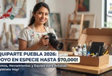Mujer artista sonriente en su estudio de arte en Puebla sosteniendo una cámara fotográfica junto a una caja con herramientas, pinturas y equipo del programa Equiparte 2026.